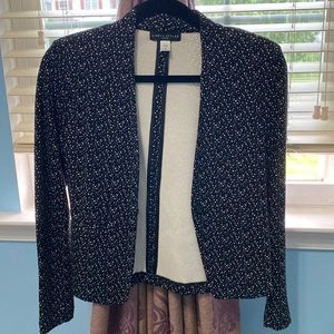 This is a new petite small blazer. It is black with a white dotted design.